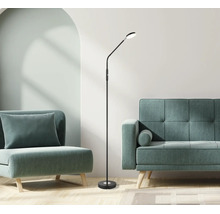 Moderne schwarze LED-Stehleuchte mit flexiblem Arm in einem hellen Wohnzimmer mit Polstermöbeln und Holzboden.