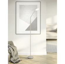 Moderne Stehleuchte mit flexiblem Hals in einem hellen Wohnzimmer mit Sofa, Teppich und einem abstrakten Bild an der Wand.