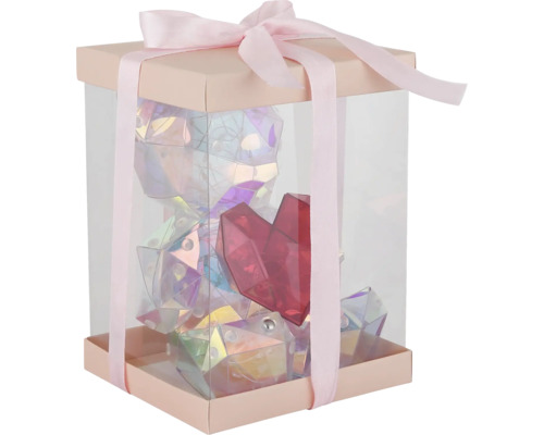 Geschenkbox mit durchsichtigen Wänden und Schleife, gefüllt mit einem glänzenden, facettierten Bären und einem roten Herz.