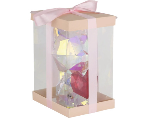 Geschenkbox mit Schleife, transparenter Verpackung und einem glänzenden, facettierten Bären mit Herz im Inneren