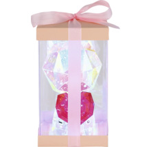 Geschenkbox mit einer transparenten Figur, die ein Herz hält und mit Schleife verziert ist