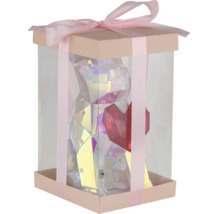 Geschenkbox mit transparenten Wänden, gefüllt mit einer glänzenden Bärenfigur mit Herz und verziert mit einer Schleife.