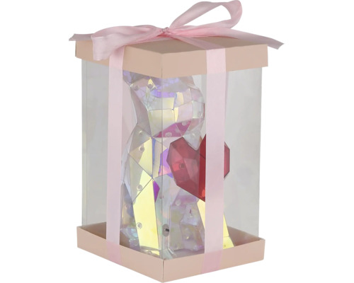 Geschenkbox mit transparenten Wänden, gefüllt mit einer glänzenden Bärenfigur mit Herz und verziert mit einer Schleife.