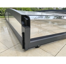 Flache Poolüberdachung aus anthrazitfarbenem Aluminium mit transparenten Paneelen, Detailansicht von Rahmenecke und Rolle.