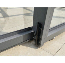 Detailaufnahme eines Bolzenriegels an einem Schiebetürelement aus Aluminium und Glas.