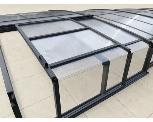 Teleskopische Poolüberdachung mit anthrazitfarbenem Aluminiumrahmen, Seitenschiebetür und transparenten Platten aus Polycarbonat.
