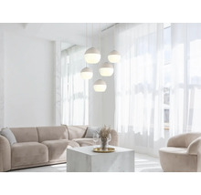 Fünfflammige Pendelleuchte mit kugelförmigen Schirmen in einem hellen, modernen Wohnzimmer mit beigem Sofa und Couchtisch.