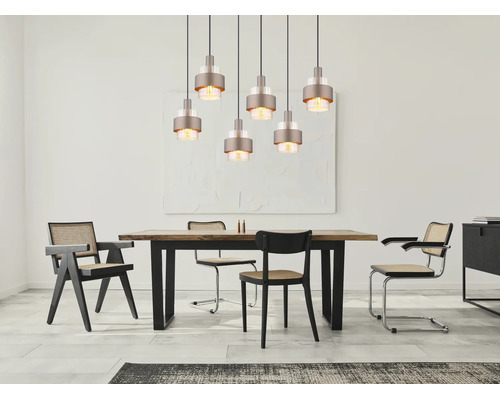 Modernes Esszimmer mit einer 7-flammigen Pendelleuchte über einem Holztisch und Stühlen mit Wiener Geflecht.