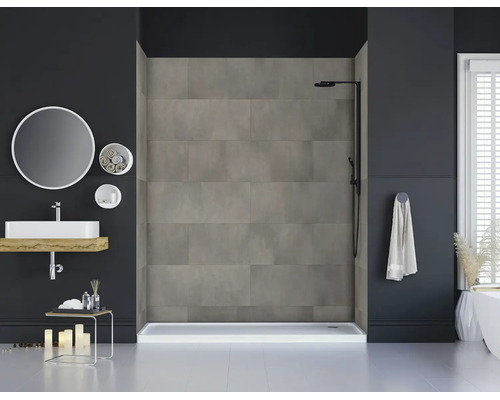 Modernes Badezimmer mit einer begehbaren Dusche, verkleidet mit grauen Wandpaneelen in Betonoptik, einem schwarzen Duschsystem und Waschbecken.