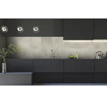 Moderne, minimalistische Küche mit dunklen grifflosen Fronten, einer Küchenrückwand in Betonoptik und eleganten Glas-Pendelleuchten.