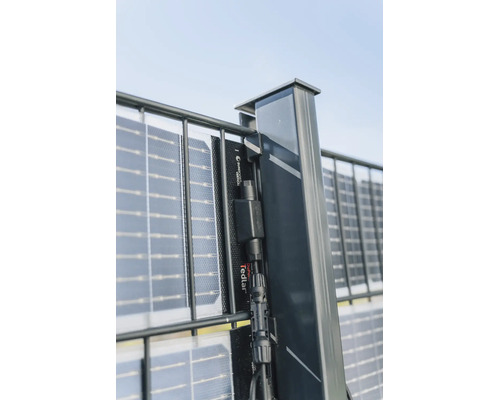 Vertikales Solarmodul als Sichtschutz befestigt an einem Doppelstabmattenzaun mit Anschlusskabel am Pfosten.