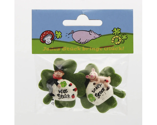 Zwei Glücksbringer mit Schornsteinfeger und Schwein auf Kleeblättern in einer Verkaufspackung.