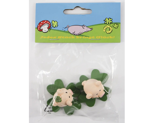 Zwei kleine Glücksschweinchen als Dekofiguren auf vierblättrigen Kleeblättern in einer Verkaufspackung.