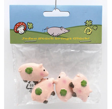 Set mit vier kleinen Glücksschweinen aus Kunststoff in einer transparenten Verpackung als Dekoration oder Geschenk.