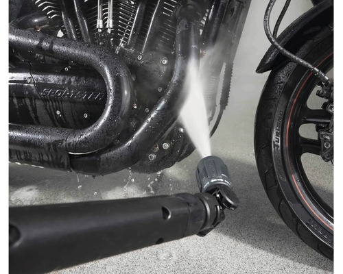 Hochdruckreiniger Düse reinigt Motorradmotor mit Wasserstrahl.