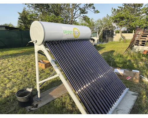 Vakuumrohrenkollektor von Green Tech zur Warmwasserbereitung im Garten auf einem Metallgestell montiert.