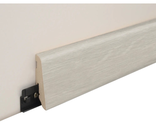 Fußleiste mit Holzoptik und zugehörigem Kunststoffbefestigungsclip an einer Wand montiert