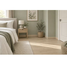 Helles Laminat in Holzoptik in einem modern eingerichteten Schlafzimmer mit Wanddekoration, Nachttisch, Pflanze und beigem Bett.