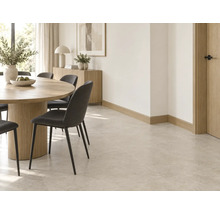 Helles Esszimmer mit Fliesenboden, runder Holztisch, dunkle Stühle, Holzsideboard und helle Wandgestaltung für ein modernes Wohnambiente.