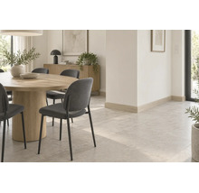 Helles, modern eingerichtetes Esszimmer mit rundem Holztisch, Stühlen und Fliesenboden in Steinoptik mit passenden Sockelleisten.