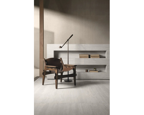 Minimalistisches Interieur mit Loungesessel aus Holz und Leder, Stehlampe und Wandregal aus Steinoptik für ein gehobenes Wohnambiente.