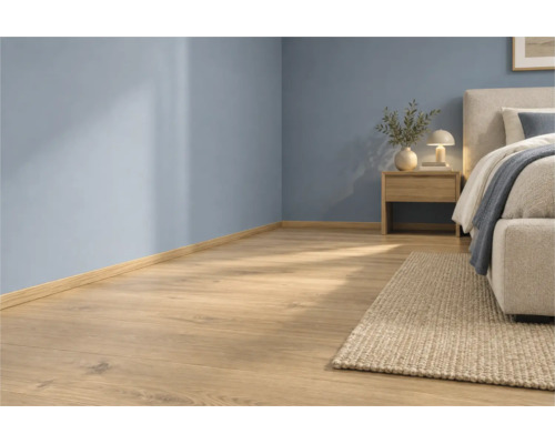 Heller Holzoptik Laminatboden in einem modern eingerichteten Schlafzimmer mit blauen Wänden und passender Sockelleiste.