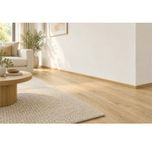 Helles Wohnzimmer mit verlegtem Laminatboden in Holzoptik und passender Fußleiste entlang der Wand.