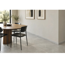 Esszimmer mit Steinfliesenboden und passenden Sockelleisten in einem modernen, hellen Wohnraum mit Holzesstisch und Stühlen.
