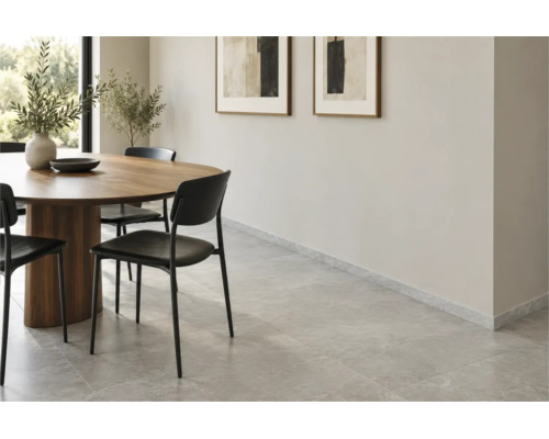 Esszimmer mit Steinfliesenboden und passenden Sockelleisten in einem modernen, hellen Wohnraum mit Holzesstisch und Stühlen.