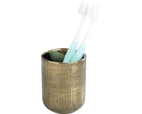 Zahnbürsten in einem goldenen Zahnputzbecher