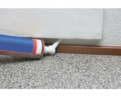Auftragen von Dichtmasse mit einer Kartuschenpistole an einer Sockelleiste