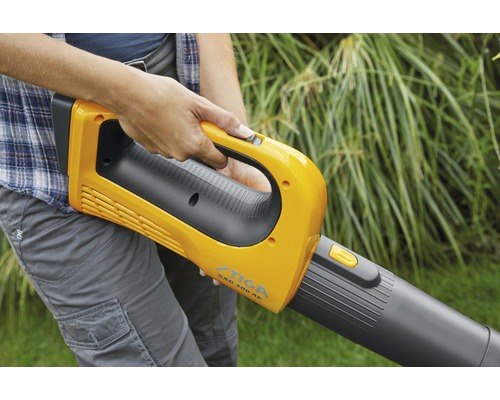Eine Person bedient einen gelben Laubbläser der Marke Stiga, Modell SAB 100 AE.