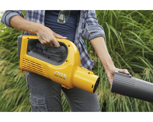Eine Person hält einen gelben Akku-Laubbläser der Marke Stiga.