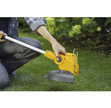 Eine Person bedient einen gelben Rasentrimmer im Garten.