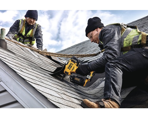 Zwei Handwerker arbeiten mit einem DeWalt Tacker auf einem Dach.