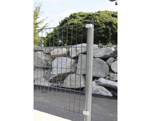 Doppelstabmattenzaun mit Pfosten und Steinmauer im Hintergrund