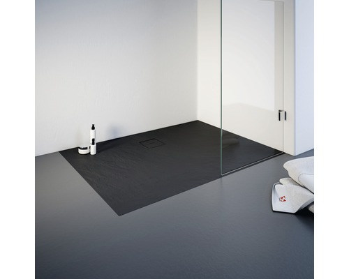 Ebenerdige Dusche mit Duschwanne aus Schiefer, Duschkabine aus Glas und Badtextilien.