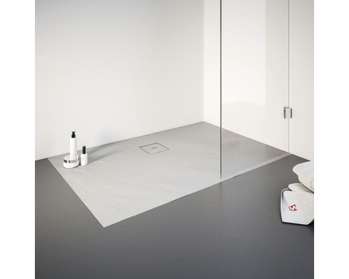 Ebenerdige Dusche mit Duschrinne, Reinigungsartikeln und Handtüchern.