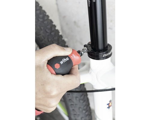 Eine Person befestigt mit einem Wiha Schraubendreher eine Fahrradsattelstütze.