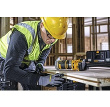 Ein Handwerker arbeitet mit einer DeWalt Oberfräse an einem Holzbrett