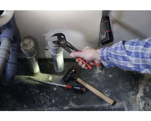 Installation einer Abwasserleitung mit Rohrzange, Hammer und Schraubenzieher