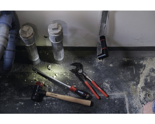 Sanitärinstallation mit Abwasserrohren, Hammer, Schraubendreher und Rohrzange.