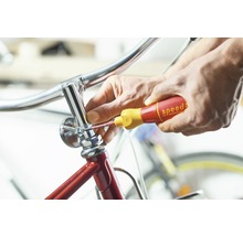 Eine Person repariert ein Fahrrad mit einem Schraubendreher.