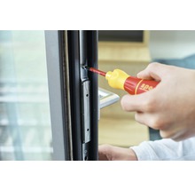 Hand montiert Beschlag am Fensterrahmen mit Schraubendreher