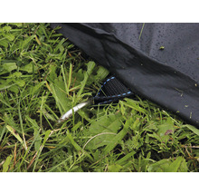 Detailaufnahme eines Zeltherings, einer Zeltabspannung und des Zeltbodens im Gras