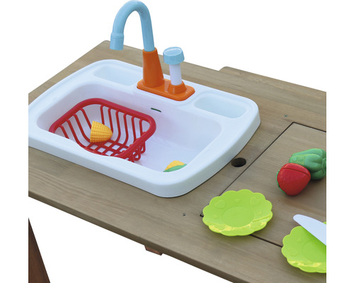 Spielküche mit Spüle, Spielzeuggeschirr und Spielzeuglebensmitteln auf einem Holztisch.
