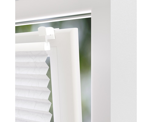 Detailansicht eines weißen Plissees am Fenster