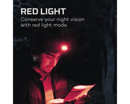 Mann mit Stirnlampe mit Rotlichtfunktion, der eine Karte im Dunkeln liest