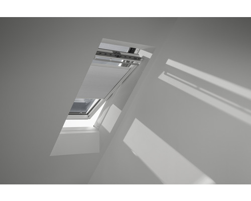 Velux Plissee-Faltstore solarbetrieben weiß uni FSC CK06 1045SWL Geöffnetes Dachfenster mit Jalousie in einem Dachgeschossraum.