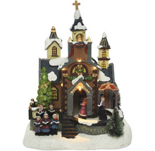 Beleuchtete Weihnachtskirche mit Chorfiguren als Dekoration